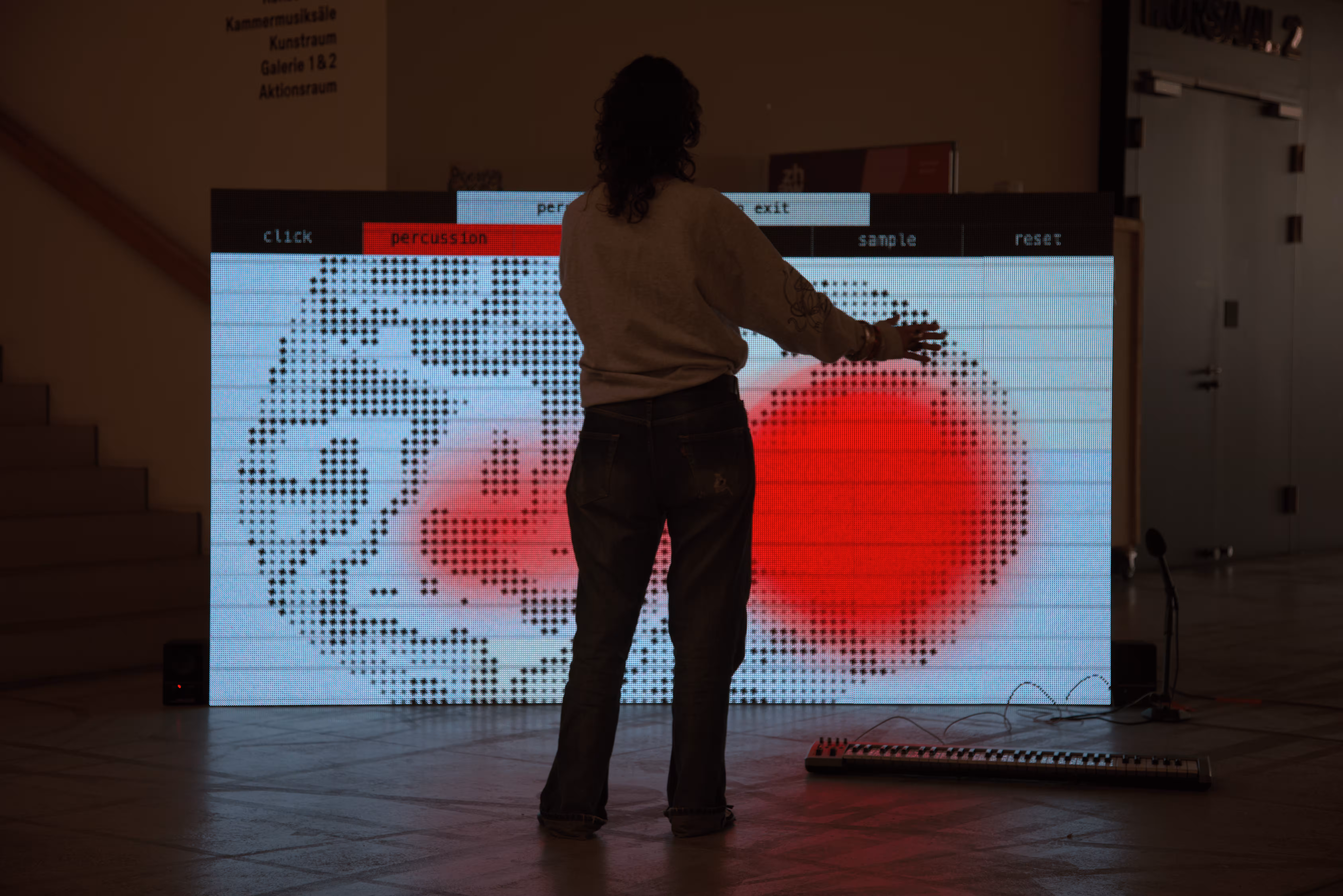 Person reaching towards the screen, red spot over a dotted pattern