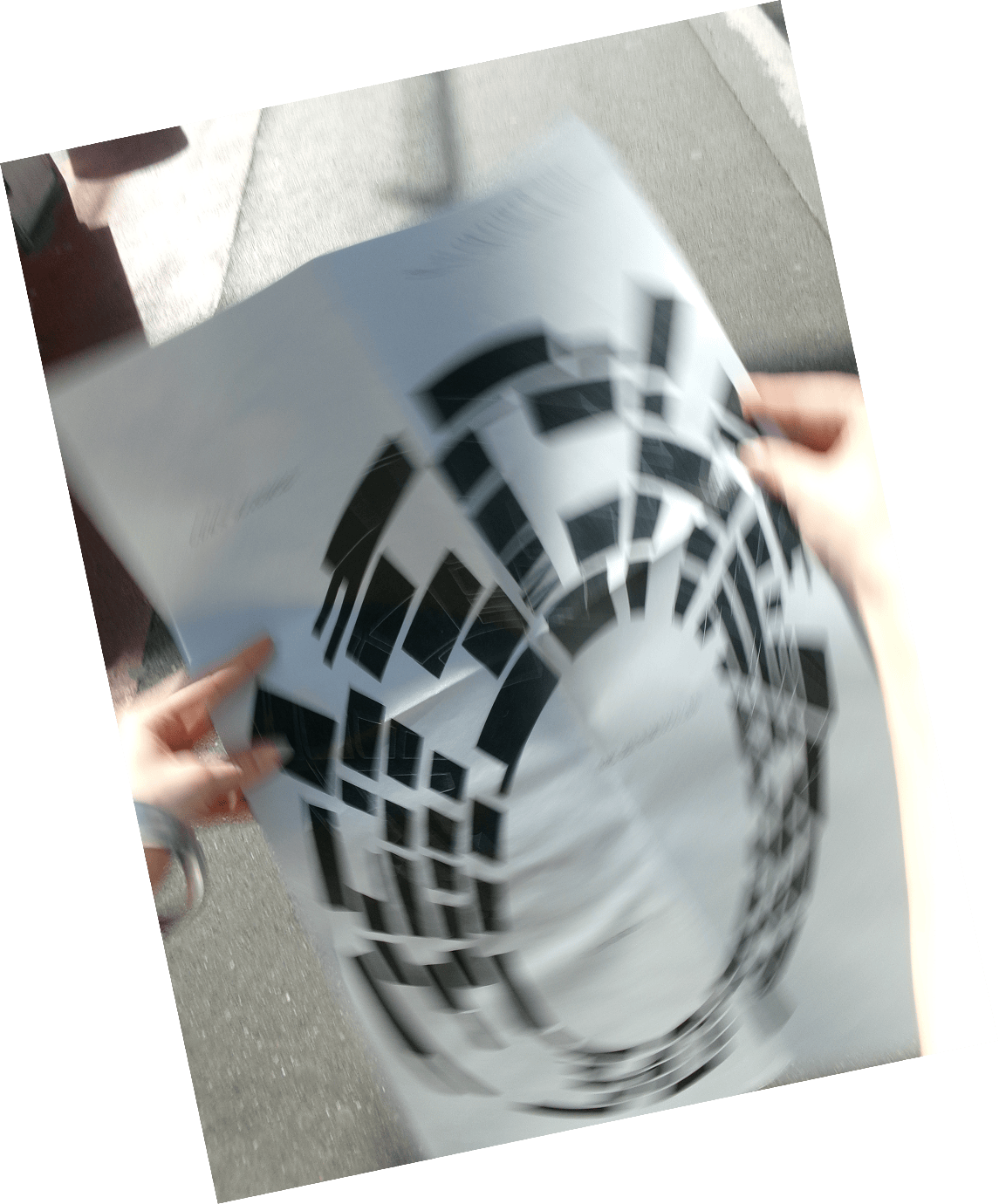 Hands holding the crumpled Schwerelos poster in the street